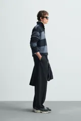 Polo relaxed fit de punto tejido en hilatura de algodón, a rayas horizontales en tonos azul y negro. Cuello solapa con cierre frontal de botonadura, manga larga y acabados en rib.