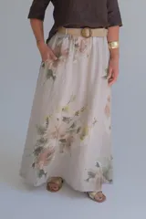 Falda larga de lino color beige con estampado floral en tonos pastel, corte amplio y cintura elastizada con cinturón de soga trenzada.