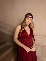 Vestido largo negro con escote en V, breteles finos con lazo y bordados florales a tono. Corte imperio y falda amplia con volados. 