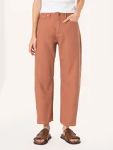 Pantalón color ladrillo de corte slouchy con cinco bolsillos y pinzas en las rodillas que estructuran la silueta con un aire urbano. Incluye metales en acabado níquel.