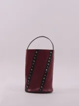 Bolso matero color bordó, de cuero, con doble asa (una de mano y otra larga desmontable), divisor interno para termo y mate, y bolsillo interior.
