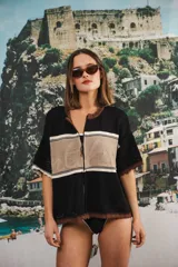 Remera de tejido calado color crudo con rayas horizontales rojas y terminaciones marrones, con cierre frontal y logo bordado.