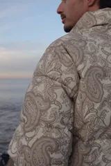 Campera puffer de corderoy con estampado paisley en tonos beige y cuello alto.
