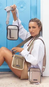 Phonebag color mostaza con bolsillo frontal con cierre, espacio para celular y billetera con repartición. Tiene una correa gruesa de galón regulable y desmontable. Detalles en marrón y beige.