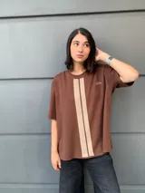 Buzo marrón de mangas cortas con cuello redondo y una franja vertical color crema en el centro.