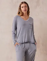 Conjunto de pijama marca René Rofé, compuesto por pantalón y remera a rayas grises y blancas. La remera es de escote en V, con bolsillo en el pecho y mangas largas. El pantalón tiene cintura elastizada y bolsillos laterales.