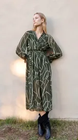 Vestido midi color violeta con estampado abstracto en dorado, escote en V, mangas largas abullonadas con elástico en los puños, y lazo para ajustar en la cintura.