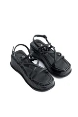Sandalias negras con plataforma y tiras cruzadas.