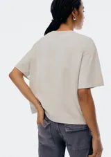 Remera color beige de corte recto, con cuello redondo y bolsillo en el pecho.