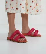 Sandalias planas con tiras puffa con nudo, color fucsia y suela naranja.