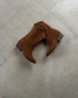 Bota de caña media color marrón, estilo western, confeccionada en gamuza con bordados decorativos en la caña y taco de 5cm.