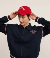 Gorra roja de sarga de algodón con visera curva, ajuste trasero y parche bordado con la palabra "Paris" en blanco.