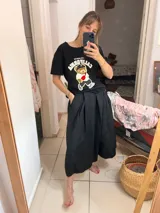 Pollera midi negra de corte amplio con cintura alta y cinto de la misma tela.