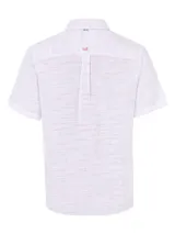 Camisa de manga corta blanca con textura multicolor, confeccionada en lino orgánico y tencel. Tiene bolsillo en el pecho con botón.