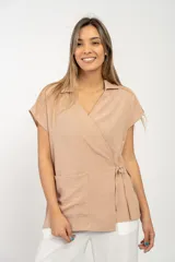 Blusa color beige con cuello camisero, corte cruzado, mangas cortas y lazo lateral.