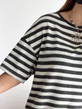 Vestido corto de tejido de punto a rayas horizontales en blanco y negro, con corte oversize y mini tajos laterales.