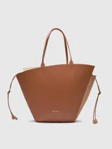 Bolso tipo capazo de cuero color marrón, con doble asa de hombro y cierre lateral con cordones.