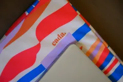 Porta laptop impermeable con diseño abstracto en colores vibrantes, disponible en dos tamaños.