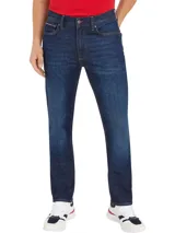 Jeans de corte recto color azul oscuro, con diseño de cinco bolsillos, cierre de botón y cremallera, cinta distintiva de Tommy Hilfiger sobre el bolsillo delantero y parche con logo en la parte posterior.