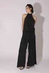 Conjunto de pantalón y top de seda color gris, con cuello halter y corte holgado.