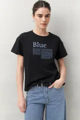 Remera blanca de manga corta con estampado tipográfico azul en el frente.
