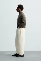 Jersey negro de corte boxy fit, tejido en hilatura con mezcla de algodón y 13% de cashmere. Tiene cuello redondo, manga larga y acabados en rib.