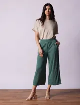 Pantalón capri plisado color beige, marca Dictionary, con pretina ancha elastizada y bolsillos delanteros.