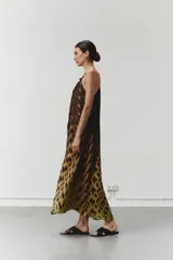 Vestido largo con cuello halter y corte fluido, con estampado animal print en tonos marrones y amarillos. Confeccionado en satén de viscosa.