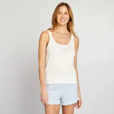 Conjunto de pijama blanco compuesto por una camiseta de tirantes con la inscripción "Good Night" y un short a rayas verticales azules y blancas.