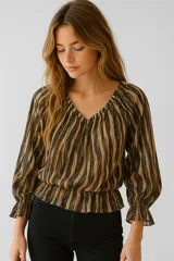 Blusa de poliéster con estampado abstracto en tonos beige y negro, escote en V con frunce, mangas largas abullonadas con puños elásticos y corte a la cintura con elástico.