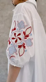 Camisa blanca de algodón con mangas abullonadas y bordados en color bordó, celeste y rosa pastel.