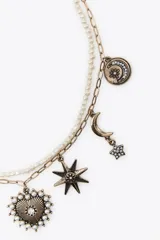 Set de dos collares: uno con cadena metálica con mini perlas y cierre de mosquetón, y otro con cadena de eslabones metálicos y colgantes de charms variados con cierre de mosquetón.