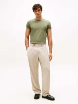 Remera verde militar de algodón elástico con cuello redondo y corte extra slim. Presenta logo de Tommy Hilfiger bordado en el pecho y cinta distintiva en el interior del cuello.