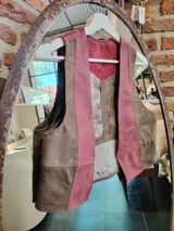 Chaleco de cuero marrón y rosa con diseño de bloques de color. Tiene cuello en V y cierre con botones. El interior está forrado en tela suave.