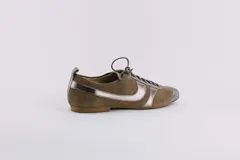 Zapato tipo ballerina acordonado, color marrón con detalles en plateado. Fabricado en cuero.