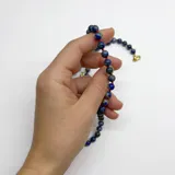 Collar de cuentas de lapislázuli de 6mm con separadores de hilo rojo y cierre de mosquetón dorado.