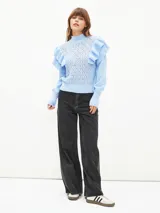 Sweater lila de tejido calado con cuello alto y mangas largas abullonadas con volados.