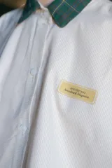 Camisa de algodón a cuadros beige y blanco con cuello tartán verde, manga larga y corte oversize boxy.