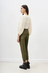 Pantalón tipo babucha color verde militar, confeccionado en gabardina elastizada, con ajuste en tobillos y cintura regulable con cordón a tono. Cuenta con bolsillos diagonales en el frente y bolsillos con solapa y botón en la parte trasera.