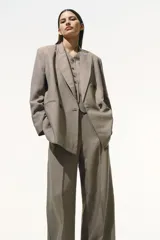 Pantalón de vestir color gris topo, de tiro alto, corte amplio y largo hasta el tobillo. Confeccionado en tejido liviano de mezcla de lino y viscosa.