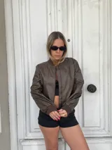 Campera bomber marrón de cuero sintético con cierre frontal y puños elastizados.