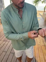 Camisa de manga larga color verde claro con cuello mao y botones frontales de madera.