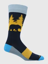 Calcetín de largo medio, color azul marino, con diseño estampado de un oso negro y árboles amarillos en el tobillo. El talón y la punta son de colores contrastantes (azul claro, gris y amarillo).