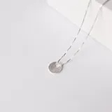 Gargantilla de plata 925 con cadena de eslabones finos y dije circular esmerilado con un orificio.