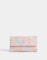Billetera de cuerina con estampado floral multicolor, formato fichero con solapa y broche en forma de corazón. Cuenta con compartimentos para tarjetas y billetes.