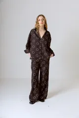 Conjunto de camisa y pantalón marrón con estampado de círculos blancos.