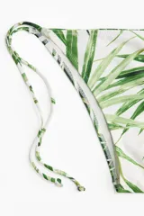 Vedetina blanca con estampado de hojas de palmera verdes y tiras laterales para atar.