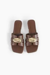Sandalias de cuero color chocolate con taco bloque bajo, punta cuadrada y tiras cruzadas con detalle metálico dorado.