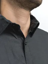 Camisa de manga larga, color blanco, con cuello camisero y botones frontales. El tejido presenta una textura visible de lino.