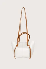 Bolso blanco de cuero sintético con textura granulada. Tiene doble asa corta y correa larga de cuero marrón.